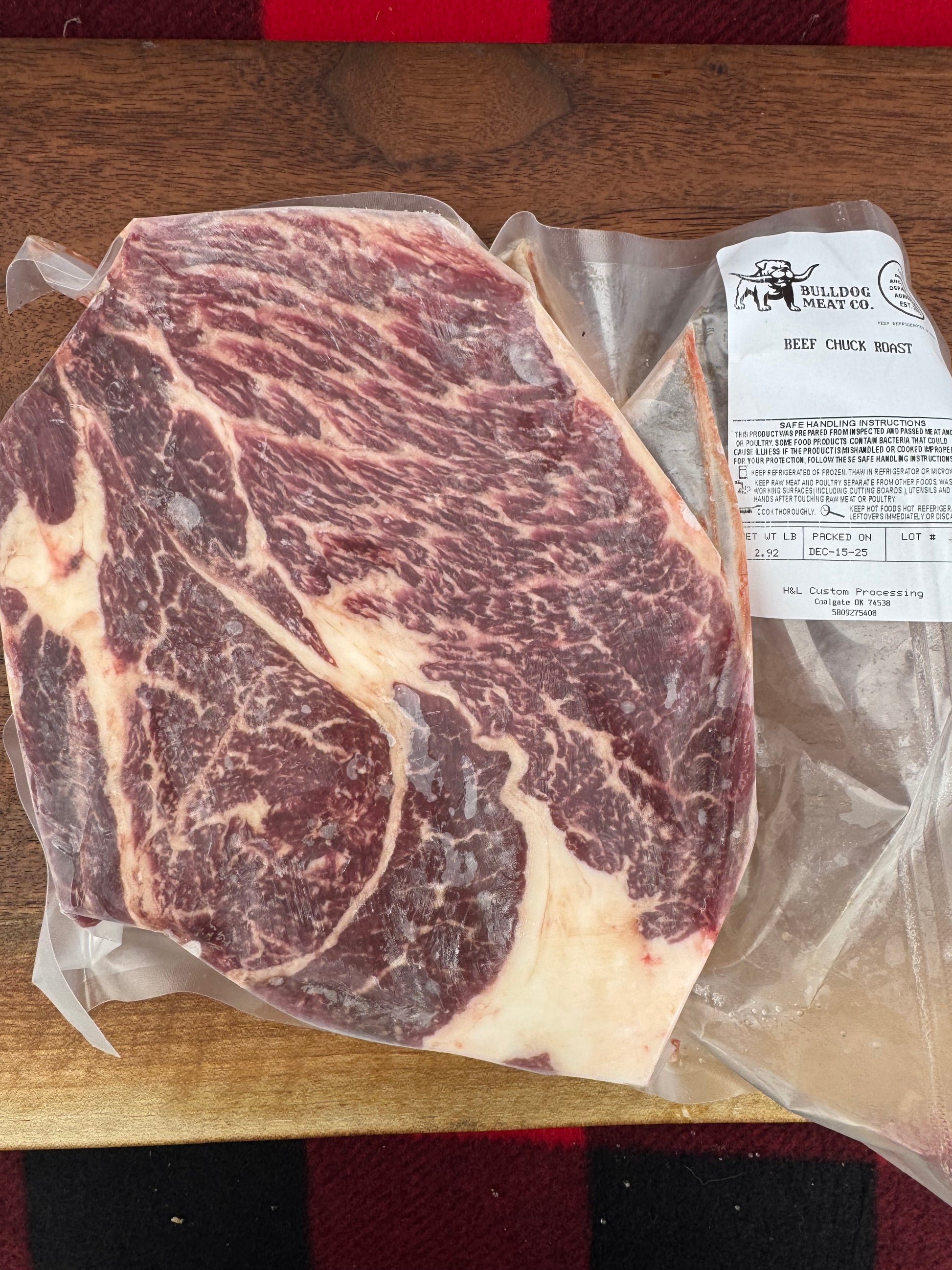 Marbled raw steak on a wooden surface with a checkered background