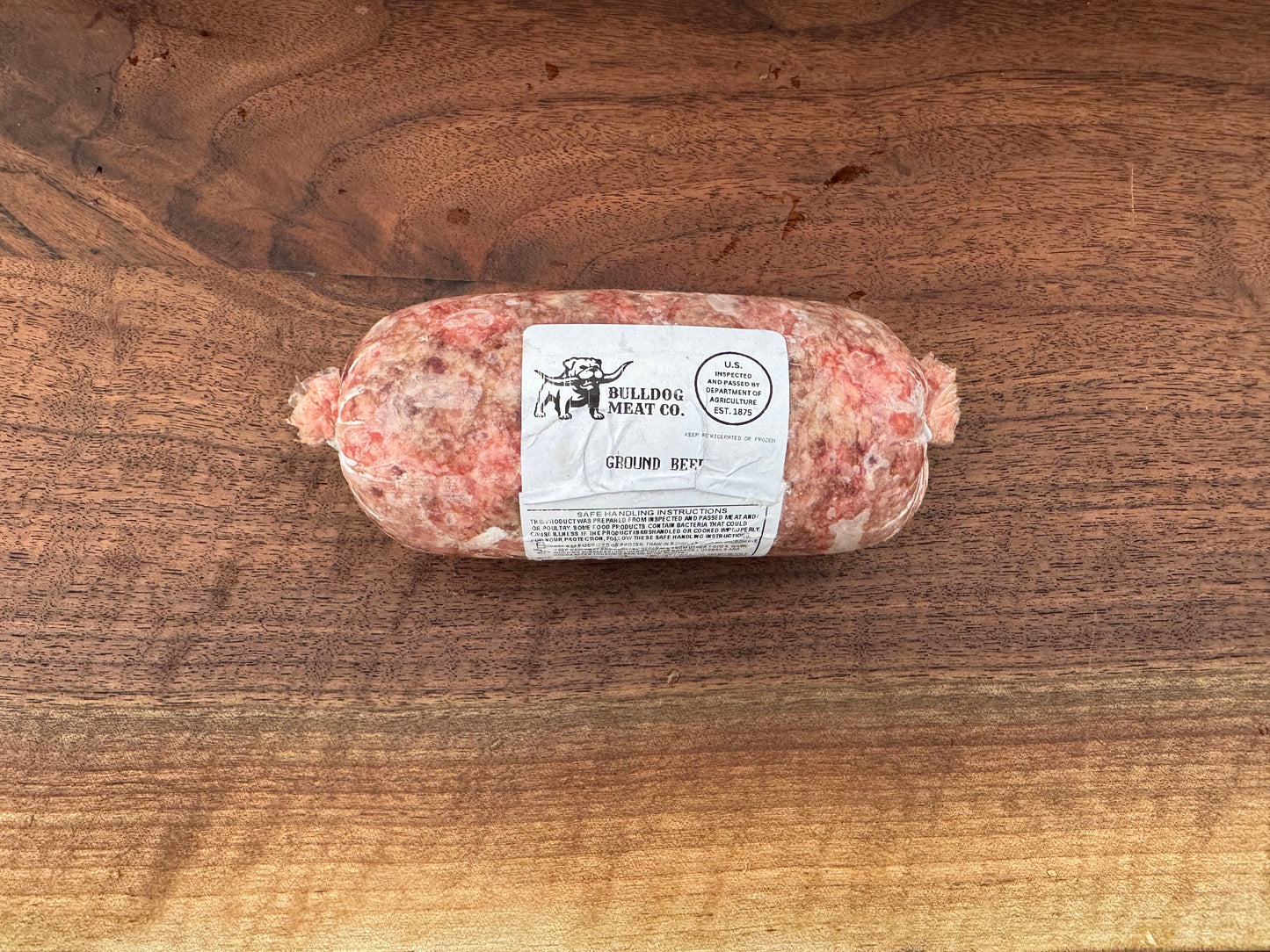 Rolled meat product with a label on a wooden surface