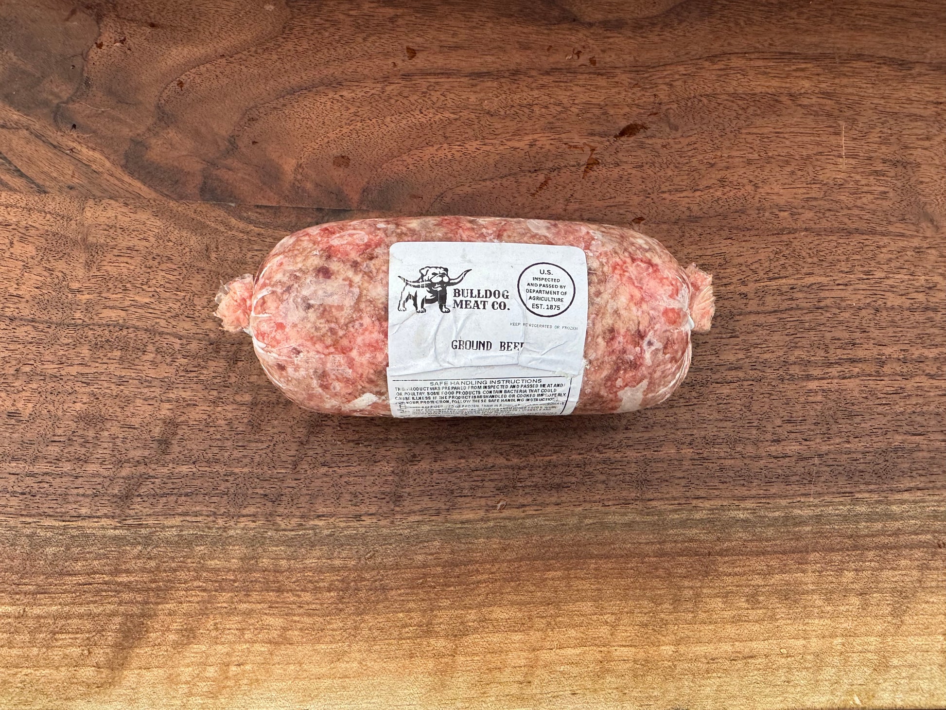 Rolled meat product with a label on a wooden surface